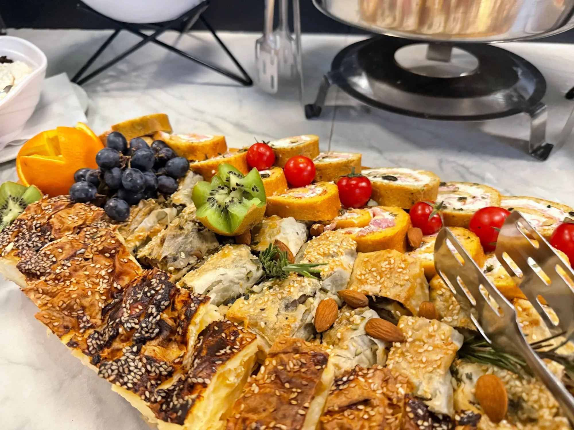 Pite sa susamom, slani rolati, grožđe i čeri paradajz na švedskom stolu u restoranu Akvarel